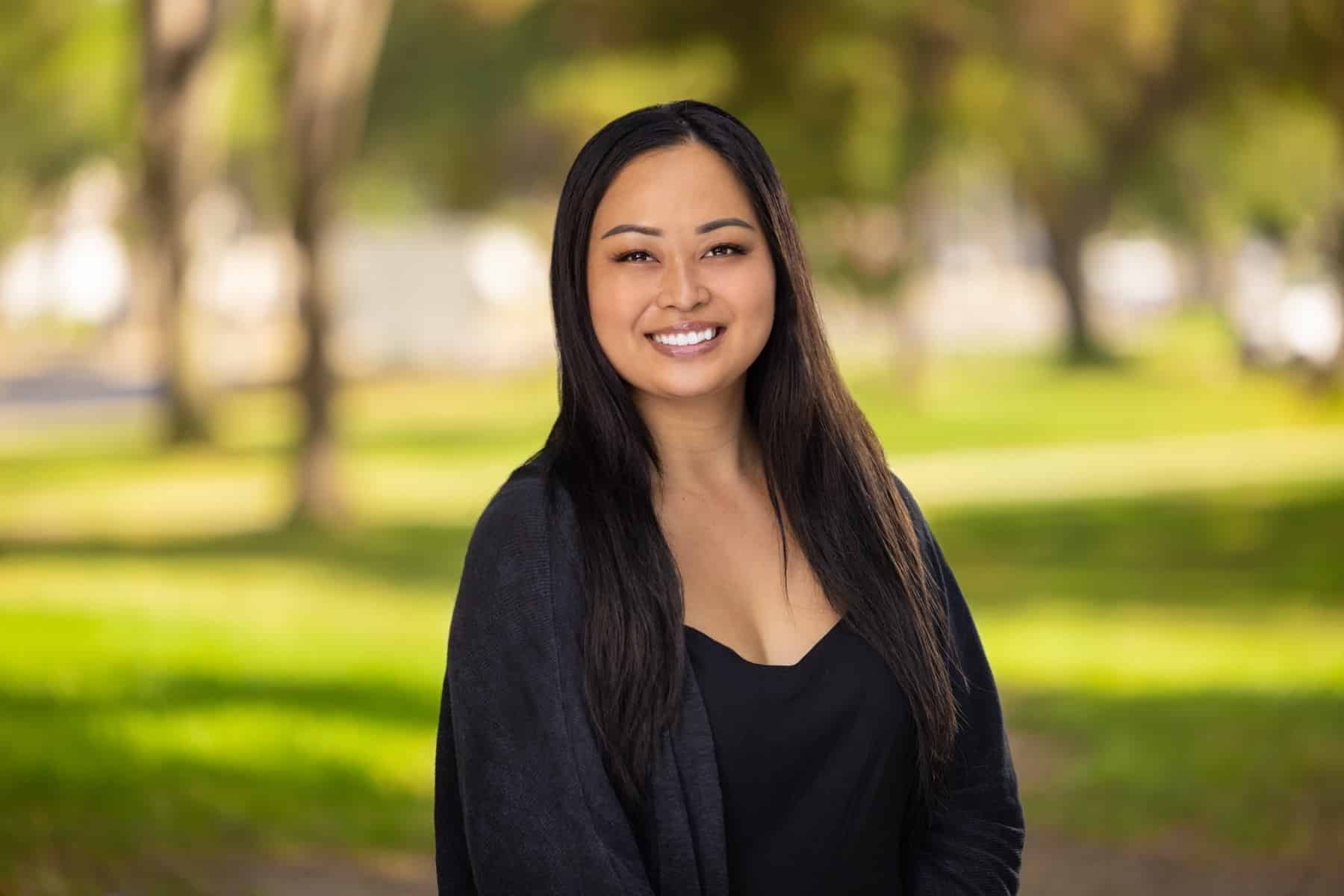 Catherine Chacon, smiling in a dark cardigan outdoors