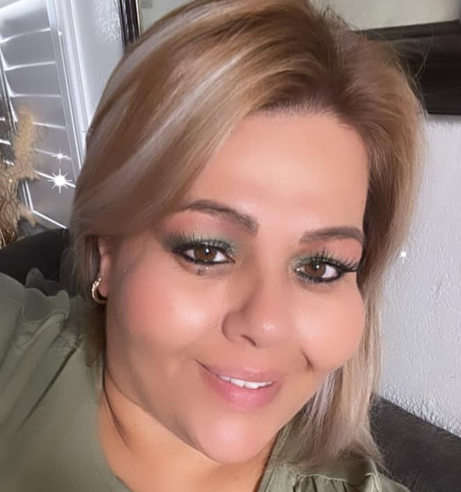 Marcela, smiling in an olive green top